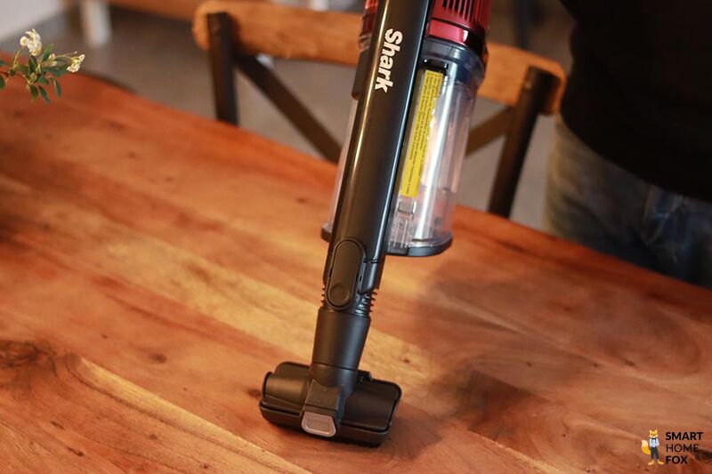 Man sieht, wie man mit dem Shark Anti Hair Wrap Handstaubsauger Möbel reinigt.